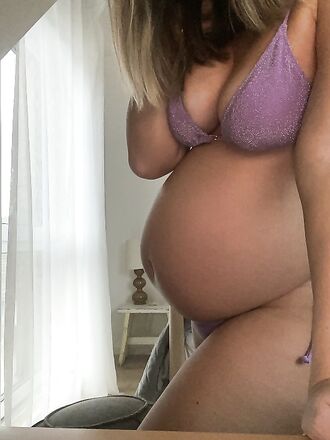 Raskaana oleva lutkainen tyttö näytti ison vatsansa kameralle